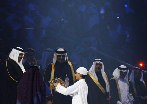 A young Qatari boy hands over the astrolabe to HH The Emir Sheikh Hamad Bin Khalifa Al-Thani (L) © Getty Images
