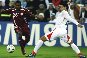 Qatari footballer dribbles past Iranian tackle attempt © Getty Images