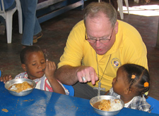 Archbishop Timothy Dolan visits children at the parish run nutrition center