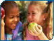 two children eating shiny apples