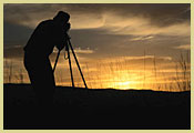[Photograph]: A photographer is taking a picture of the sunset.