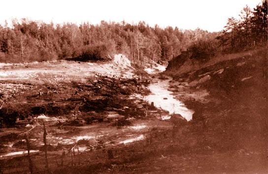 Photo of Lakebed and remains of Kelly Barnes Dam. 
(View downstream)
