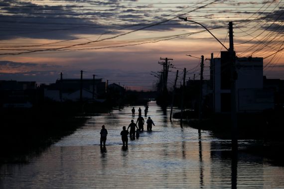 People walk along a flooded street of Eldorado do Sul, Rio Grande do Sul, Brazil on May